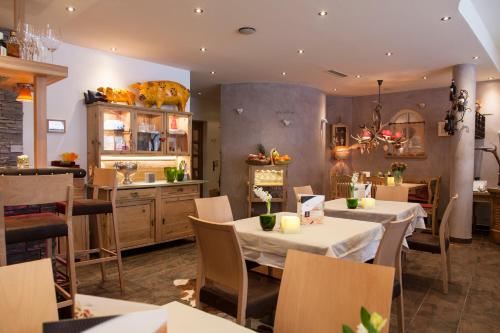 a restaurant with tables and chairs and a kitchen at Am Dorfplatz Suites - Adults friendly in Sankt Anton am Arlberg