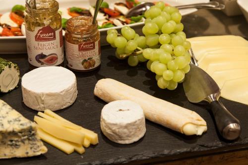 a table with cheese and a bunch of grapes at Am Dorfplatz Suites - Adults friendly in Sankt Anton am Arlberg