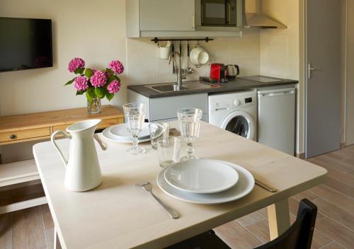 a kitchen with a table with plates and glasses on it at Revigora in Vienne