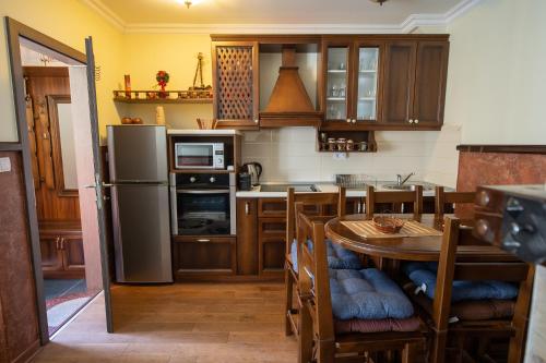 uma cozinha com uma mesa e um frigorífico em Like Home Lux, Apartman A9 em Kopaonik