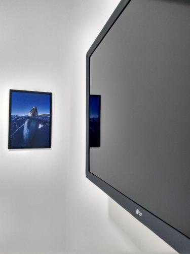 a computer screen and a picture on a wall at Zen Pousada in Telêmaco Borba