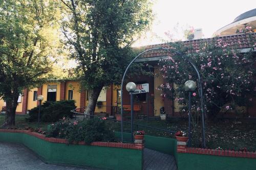 a building with flowers and plants in front of it at RistHotel Pianura Inn in Busnago