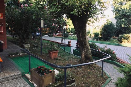 a park with a green slide next to a tree at RistHotel Pianura Inn in Busnago