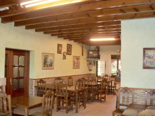 a restaurant with wooden tables and chairs in a room at Posada Casa de Julia in Parbayón