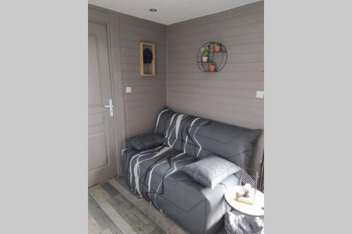 a living room with a couch in a room at Tiny house in Amécourt