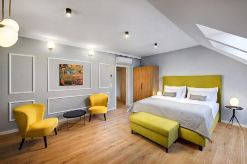 sypialnia z łóżkiem i 2 żółtymi krzesłami w obiekcie Kalix Boutique Hotel w Popradzie