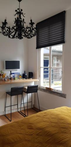 a bedroom with a desk and two chairs in front of a window at Ververs slapen in Den Bosch