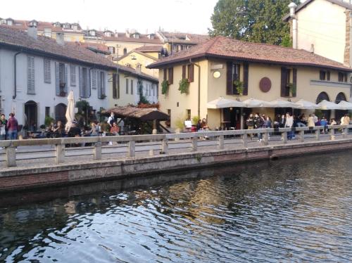 a group of people sitting at tables near a river at Taverna Zen in Milan