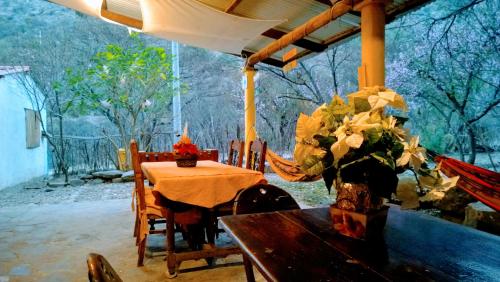 una mesa de comedor con un jarrón de flores. en La Poza del Pato, en Tarija