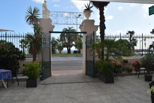 a gate to a compound with trees and a street at Hotel Lido in Varazze