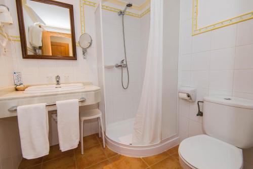 a bathroom with a shower and a sink and a toilet at Bell Port Hotel in Cala Ratjada