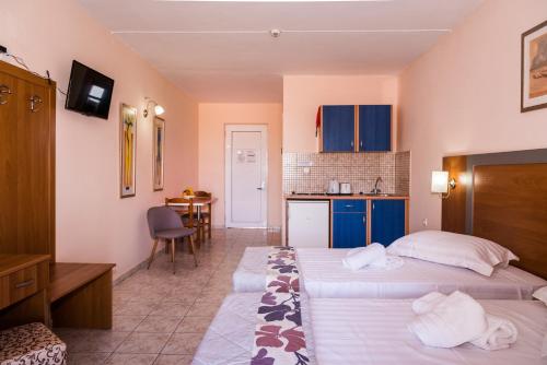 una camera d'albergo con due letti e una cucina di Macedonia a Kalamákion
