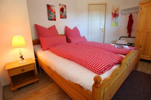 a bedroom with a bed with red and white pillows at Landhaus-Vintage, Fe-Wo Apartment 3 in Schluchsee