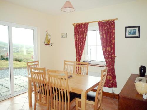 a dining room with a wooden table and chairs at Allaghee Mor St Finians Bay in Ballinskelligs