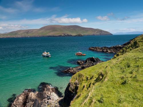 three boats in a body of water with mountains in the background at Allaghee Mor St Finians Bay by Trident Holiday Homes in Ballinskelligs