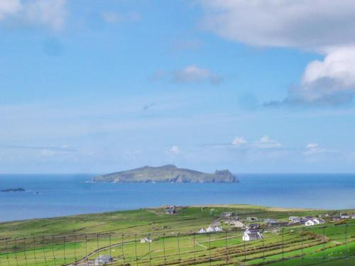 an island in the ocean next to a green field at Allaghee Mor St Finians Bay by Trident Holiday Homes in Ballinskelligs