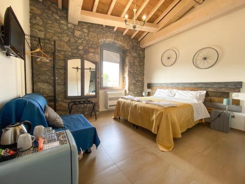 1 dormitorio con cama y pared de piedra en Casale 1541, en Bolsena