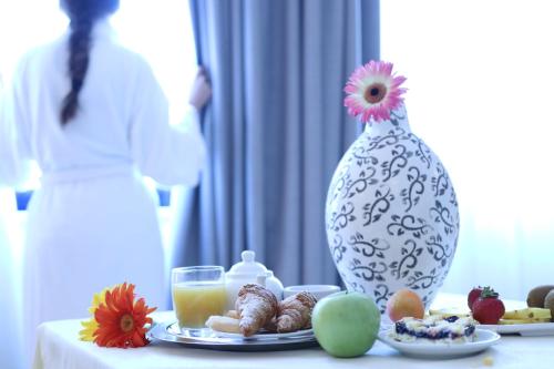 a table with a plate of food and a vase at Park Hotel Sant'Elia in Fasano