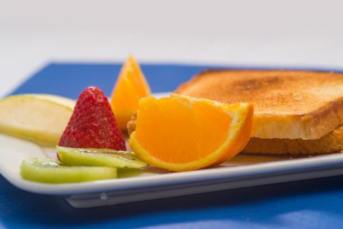a plate with fruit and toast on a blue table at Bell Port Hotel in Cala Ratjada