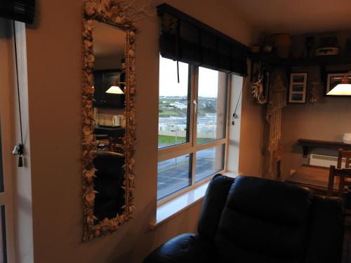 a mirror in a living room with a window at Seashell Cove Bundoran Luxurious Sea View Free Wifi Netflix Sleeps 5 in Bundoran