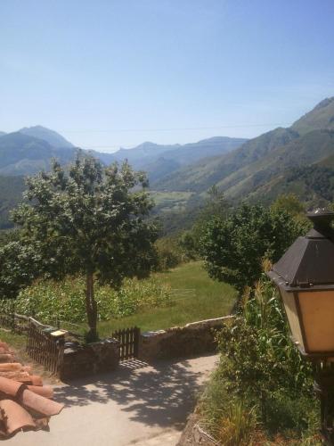 a pathway with a tree and mountains in the background at Casa Les Pedroses in Campiellos