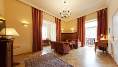 a living room with a table and chairs and a dining room at Hotel Marienhof in Reichenau