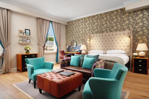 ロンドンにあるThe Bailey's Hotel London Kensingtonのベッド、ソファ、椅子が備わるホテルルームです。
