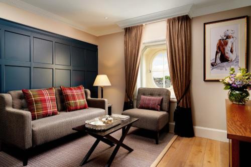 a living room with a couch and a chair and a table at The Bailey's Hotel London Kensington in London