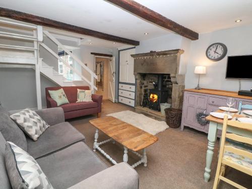 a living room with a couch and a fireplace at Millstream Cottage in Castleton