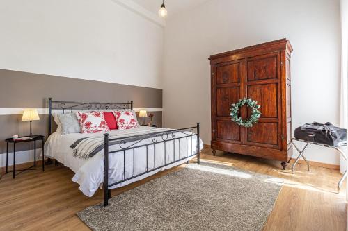 een slaapkamer met een bed en een houten dressoir bij La Grande Finestra - Appartamento con giardino in Chiusi