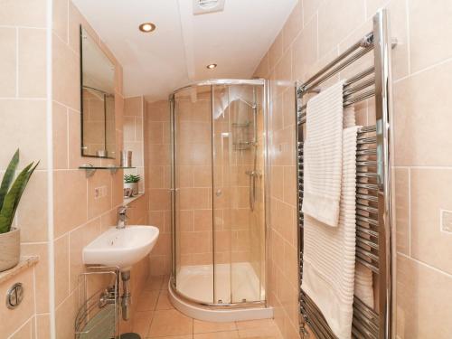 y baño con ducha y lavamanos. en Millstream Cottage, en Castleton
