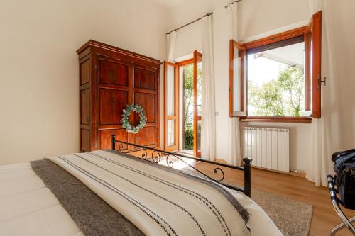 een slaapkamer met een bed en een groot raam bij La Grande Finestra - Appartamento con giardino in Chiusi