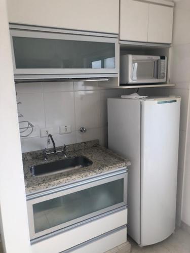 een kleine keuken met een wastafel en een koelkast bij Rua Dr Diogo de Faria, 671 apto 91 in Sao Paulo