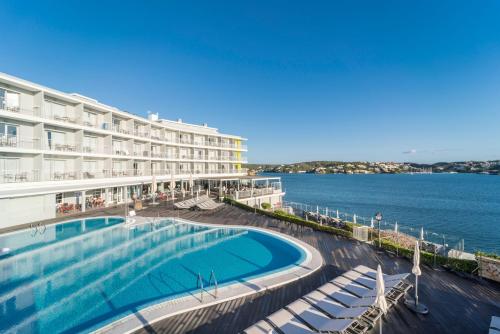 a hotel with a swimming pool next to the water at ARTIEM Carlos - Adults Only in Es Castell