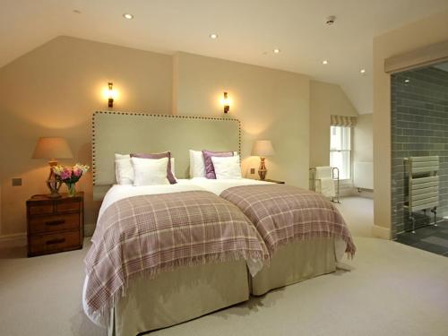 a bedroom with a large bed and two lamps at Harlech Apartments - Efnisien in Harlech