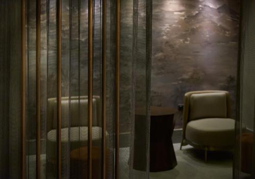 Dundar Hotel & Spa في إسطنبول: كرسيين وطاولة في غرفة مع بارات