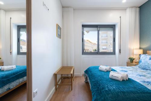 a small bedroom with two beds and a mirror at Host Wise - Anna Flats in Vila Nova de Gaia
