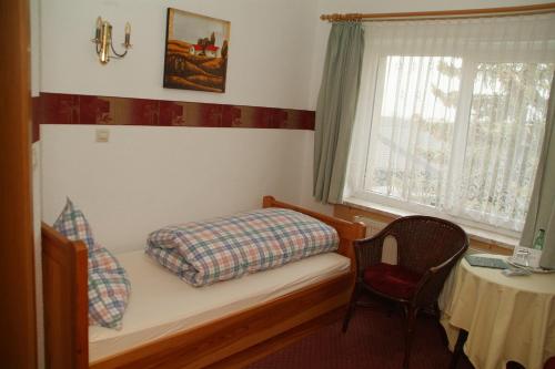 a bedroom with a bed and a window and a table at Hotel Jägerhalle in Falkenstein