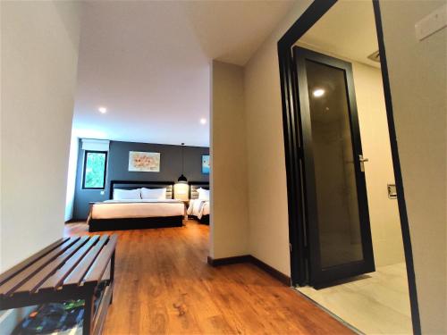 a room with a bedroom with a bed and a mirror at Apple Suites Hotel in Sitiawan