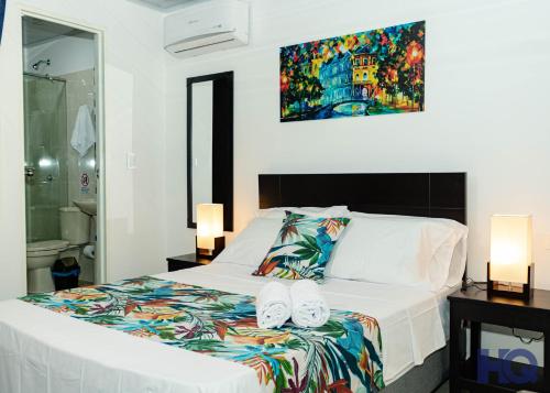 Un dormitorio con una cama blanca con toallas. en HOTEL QUILICHAO, en Santander de Quilichao
