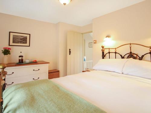 ein Schlafzimmer mit einem großen weißen Bett und einer Kommode in der Unterkunft Ty Capel Bryntwrog in Holyhead