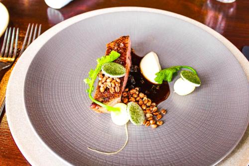 a plate with a piece of food on a table at Holbeck Ghyll Country House Hotel with Stunning Lake Views in Windermere