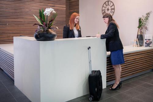 two women standing at a counter in an office at Conference Aston Hotel - Birmingham City in Birmingham