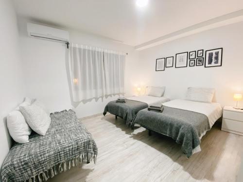 sypialnia z 2 łóżkami i kanapą w obiekcie GMC Turistics - Great Apartment for Groups & Families w Maladze