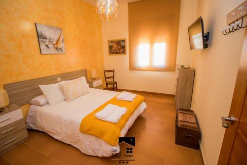 a bedroom with a bed with a yellow blanket at Casa Rural Alvaro in Albares