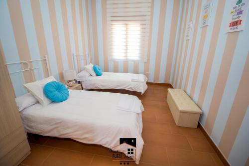 two beds in a room with blue and white stripes at Casa Rural Alvaro in Albares