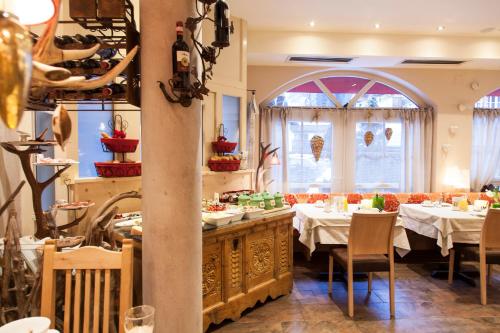 a restaurant with tables and chairs and a large window at Am Dorfplatz Suites - Adults friendly in Sankt Anton am Arlberg