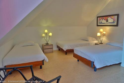 a bedroom with two beds and a staircase at Queen Serenity Hotel in Redon