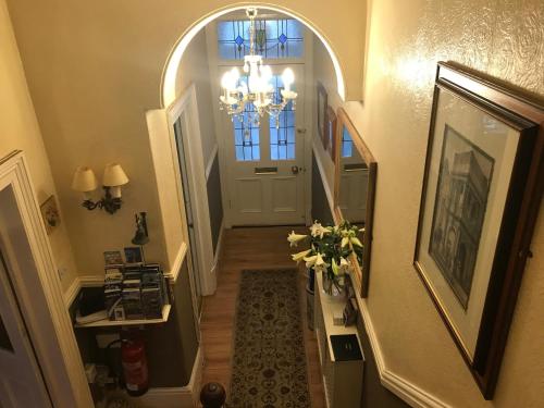 a hallway with a chandelier and a door with a window at The Welford in Harrogate