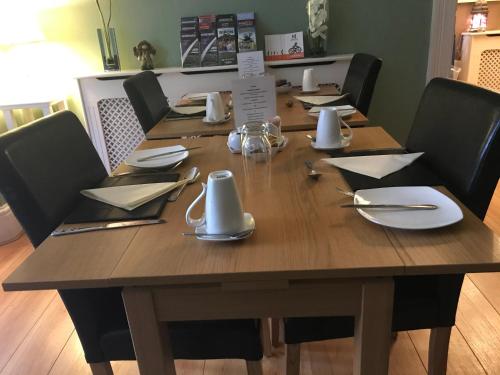 una mesa de madera con platos y utensilios. en The Welford, en Harrogate